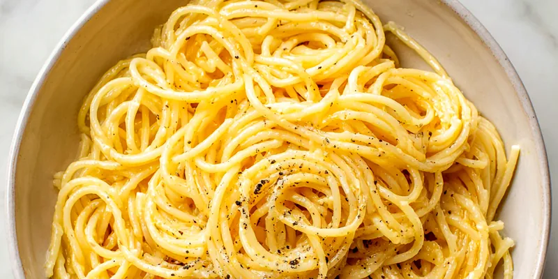 Plate of garlic butter pasta garnished with parsley and Parmesan