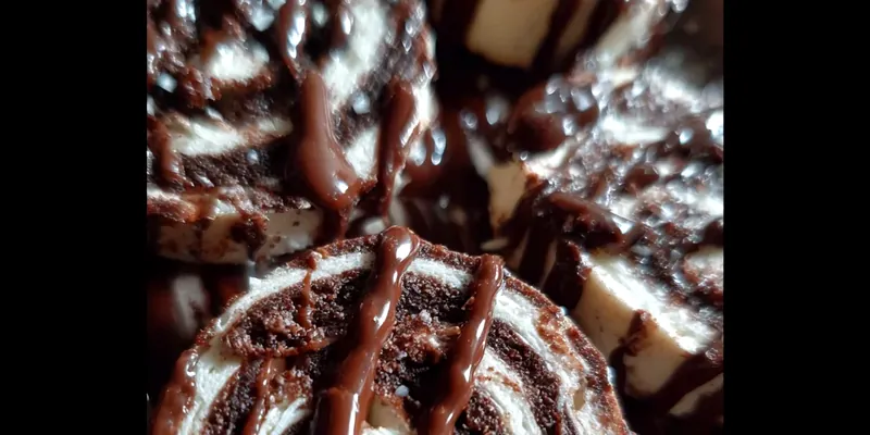 Stack of three chocolate marshmallow swirl cookies on a white plate, showing gooey marshmallow centers and rich chocolate cookie texture with visible chocolate chips