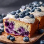 Homemade blueberry loaf with fresh blueberries on a wooden table