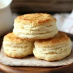 Mile High Perfect Biscuits freshly baked and served on a wooden plate.