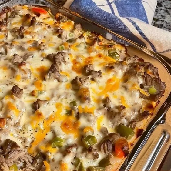 Delicious Philly cheese steak casserole topped with melted cheese and peppers