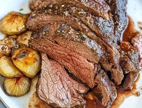 Delicious sirloin tip roast served on a platter with herbs and side dishes.