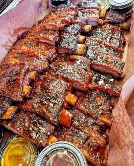 Delicious barbecue pork ribs served with a side of coleslaw and cornbread.
