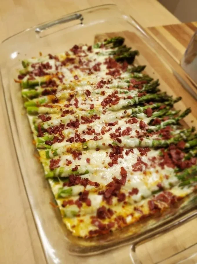 Delicious cheesy baked asparagus with bacon served on a plate