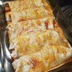 Tasty Chicken Enchiladas topped with cheese and served with fresh toppings