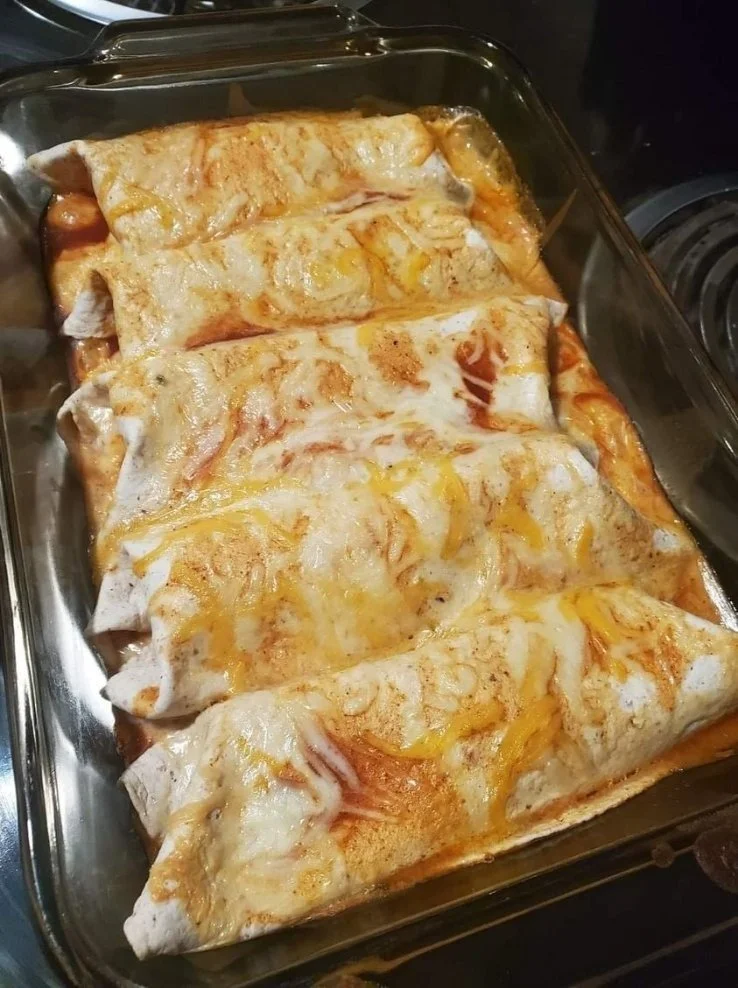 Tasty Chicken Enchiladas topped with cheese and served with fresh toppings
