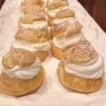 Delicious cream puffs filled with creamy vanilla filling, perfect for desserts.