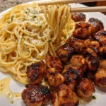 Garlic Butter Chicken bites served with creamy Parmesan spaghetti on a plate