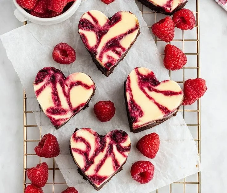 Heart-shaped brownies with cheesecake and raspberry swirl decoration