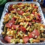 Colorful pasta salad with vegetables and dressing in a bowl