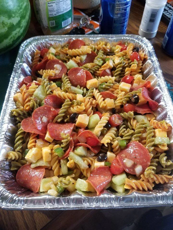 Colorful pasta salad with vegetables and dressing in a bowl