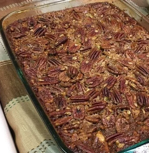 Delicious homemade pecan pie bars topped with nuts and caramel, ideal for dessert.