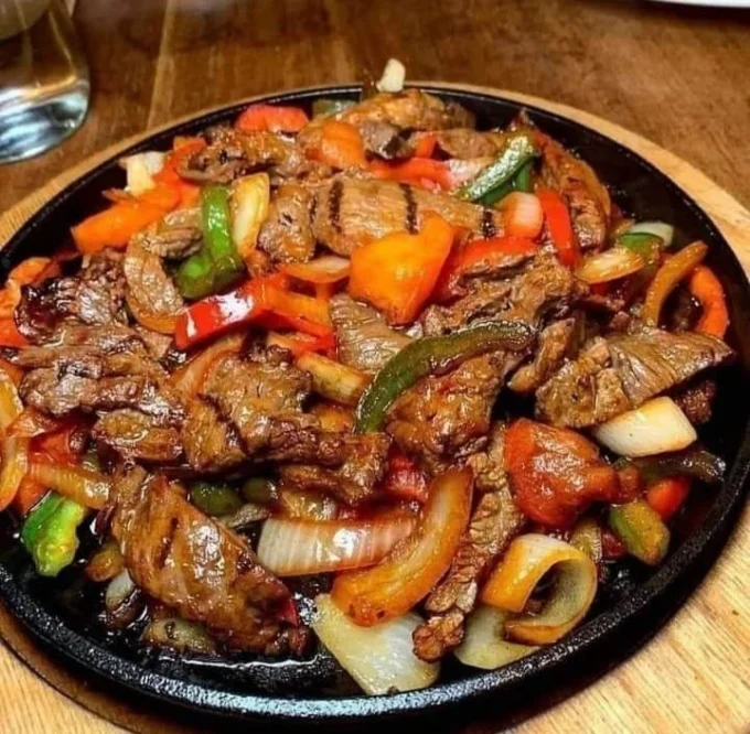 Sizzling steak fajitas with colorful bell peppers and onions on a plate