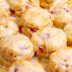 Freshly baked strawberry biscuits with a golden crust and ripe strawberries