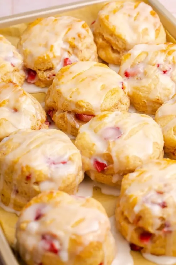 Freshly baked strawberry biscuits with a golden crust and ripe strawberries