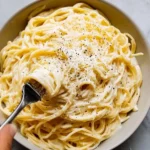 Baked cream cheese spaghetti served with garnishes in a dish