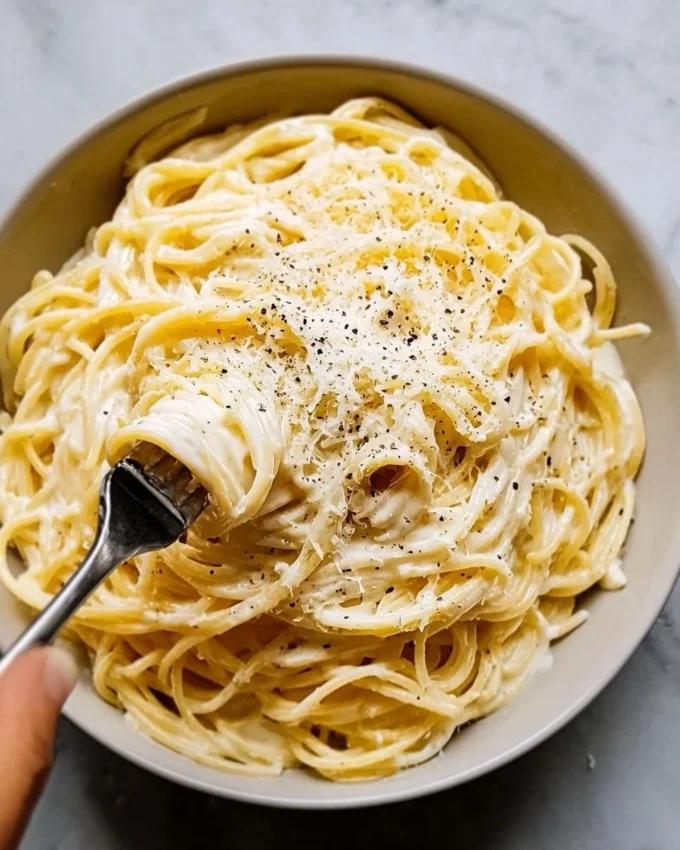 Baked cream cheese spaghetti served with garnishes in a dish