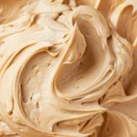 Homemade peanut butter frosting spread on a chocolate cake