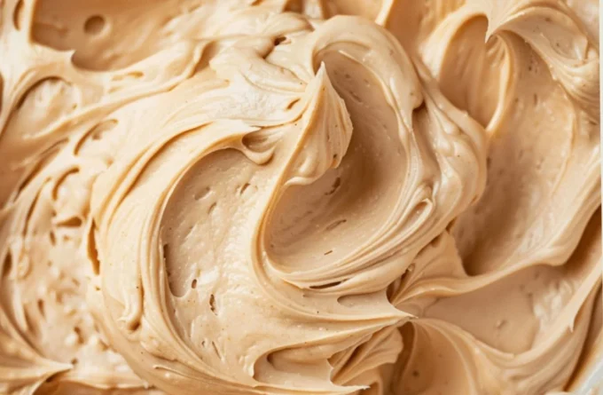 Homemade peanut butter frosting spread on a chocolate cake
