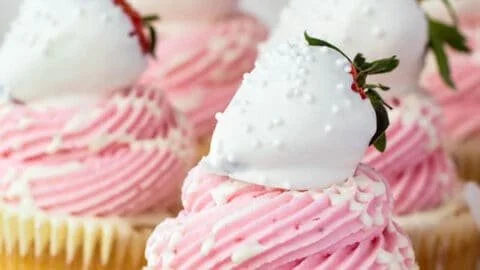 White chocolate covered strawberry cupcakes on a decorative plate