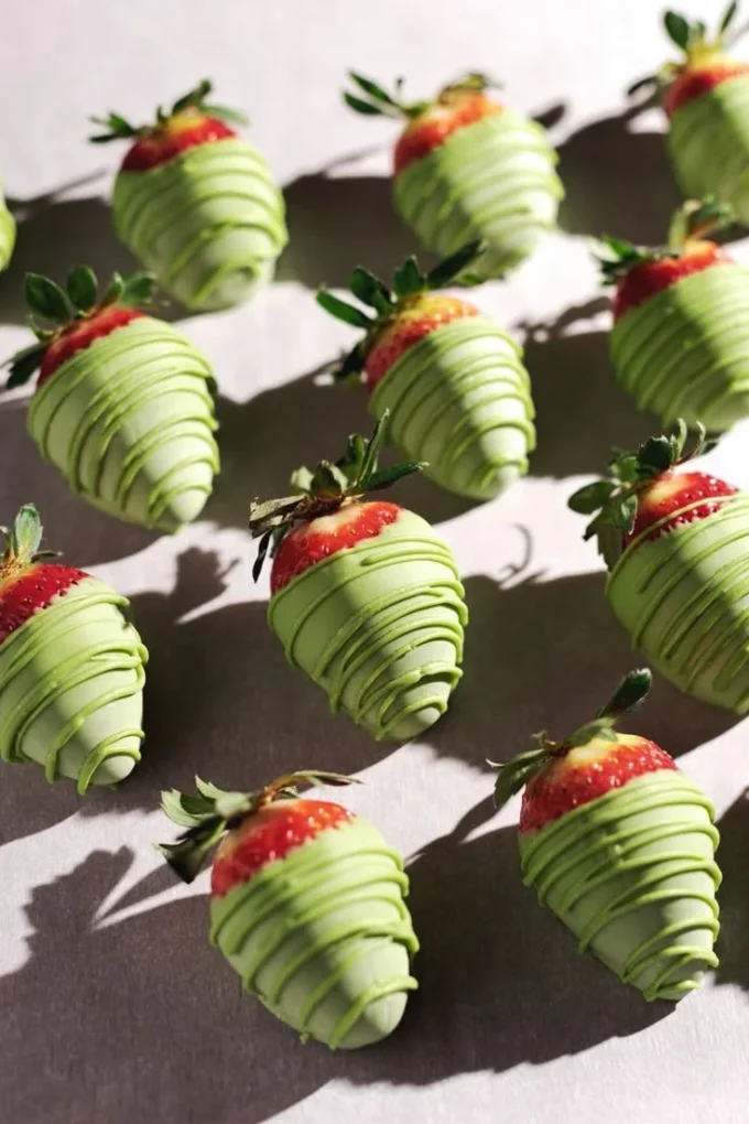 White chocolate matcha-covered strawberries on a plate, a delicious treat