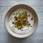 Creamy dill pickle dip served in a bowl with crackers and fresh dill