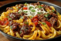 One-Skillet Zesty Honey Chili Beef Pasta dish garnished with fresh herbs.