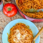 Creamy slow cooker spaghetti bolognese served in a bowl with fresh herbs