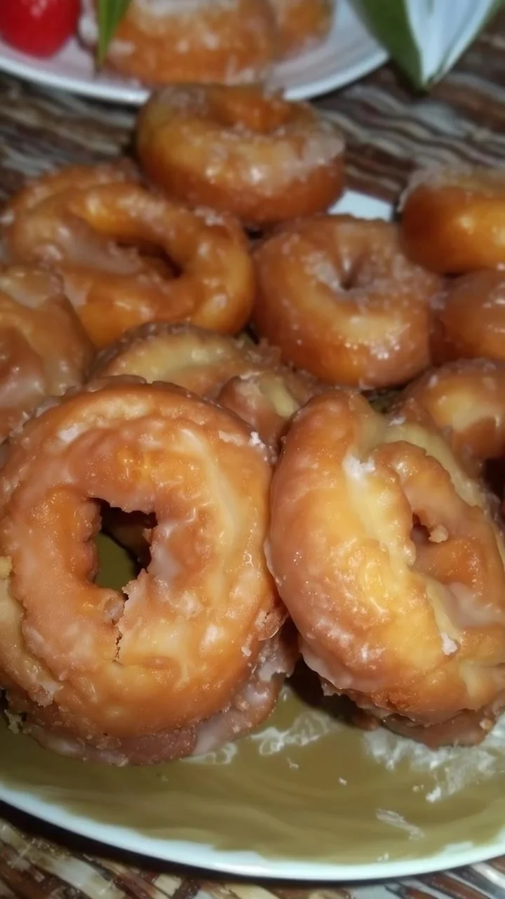 A plate of old-fashioned sour cream donuts with a dusting of powdered sugar.