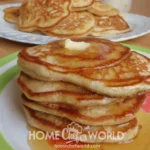 Delicious homemade pancakes stacked on a plate with syrup and berries