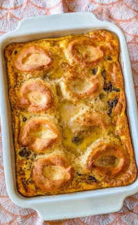 Delicious breakfast casserole with sausage, eggs, biscuits, and gravy served hot.