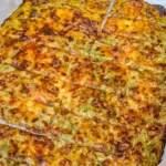 Cheesy zucchini breadsticks served with marinara sauce on a plate