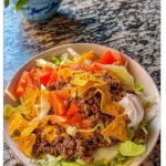 Crispy taco salad topped with Doritos and fresh ingredients