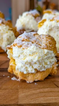 Deliciously filled dreamy cream puffs on a serving plate