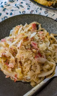 Sautéed cabbage with bacon and onions served in a skillet