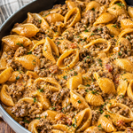 Silky Beef and Shell Pasta served in a bowl, garnished with herbs.