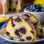 Zesty lemon blueberry pound cake slice on a plate with fresh blueberries