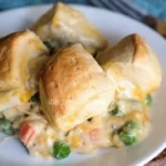 Creamy chicken pot pie topped with flaky biscuits, ideal for a comforting meal