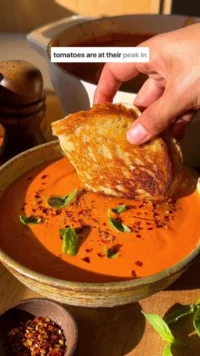 Bowl of creamy tomato soup made from scratch, garnished with fresh basil.
