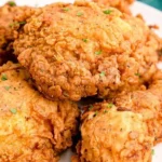 Plate of crispy buttermilk fried chicken with herbs and sides