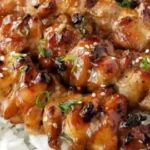 Grilled teriyaki chicken skewers on a plate garnished with green onions