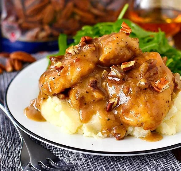 Delicious Maple Bourbon Pecan Chicken garnished with pecans and maple glaze.