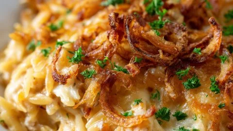 Savory French onion chicken orzo bake topped with melted cheese and herbs