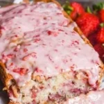 Strawberry-glazed bread showcasing a vibrant glaze and fresh strawberries on top.